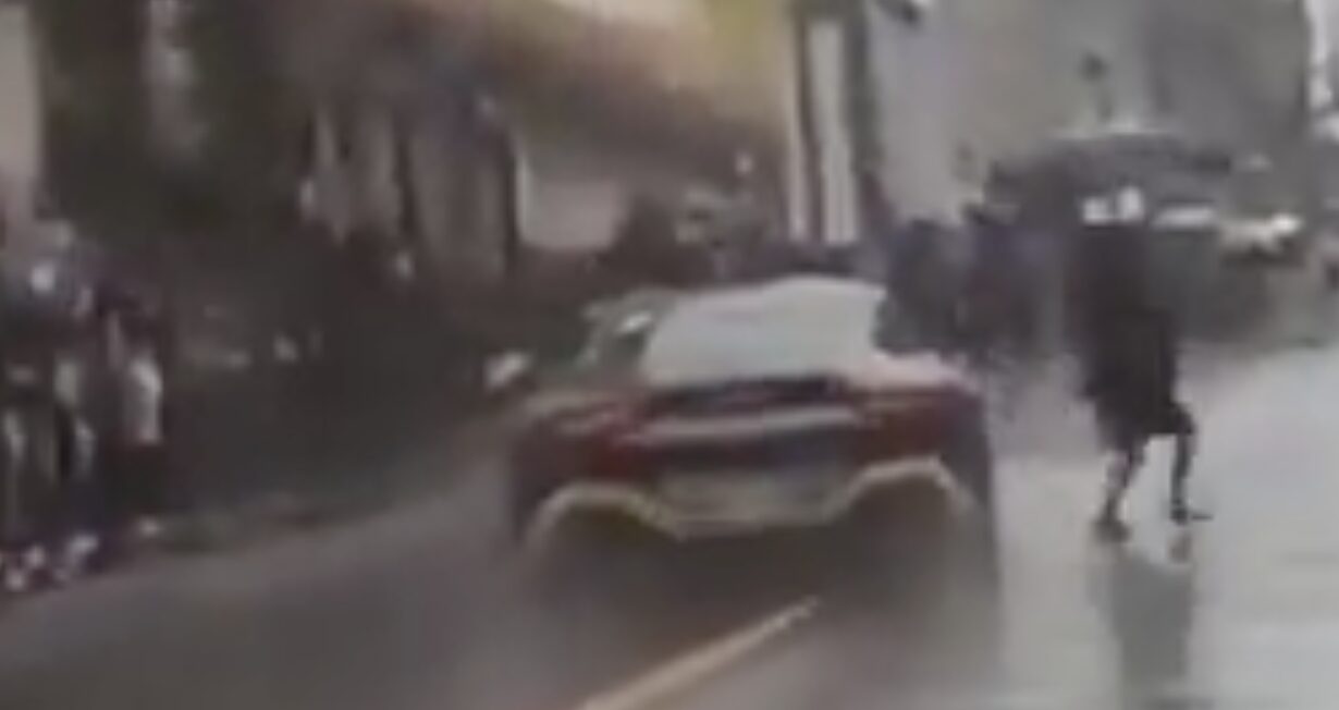 Mujer cruza sin precaución y casi es atropellada por auto de la Carrera Panamericana en Teziutlán